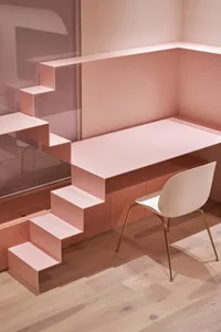 A minimalist interior with a metal staircase and desk.