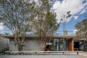 A modern house featuring a minimalist design with concrete walls and a glass door.