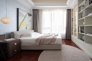 A modern bedroom featuring a white fabric upholstered bed, white walls, and a large window with curtains.