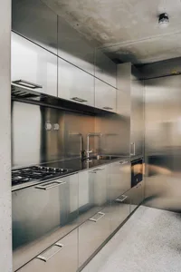 Modern kitchen with stainless steel cabinets, countertops, and appliances.
