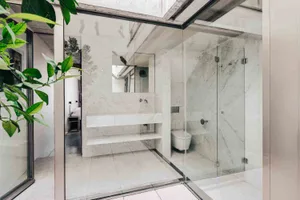 Modern, minimalist bathroom featuring marble walls and floor.