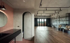 A modern living room featuring cement walls, wooden flooring, and metal accents.