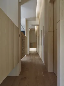 Modern minimalist narrow corridor with wooden flooring and walls.