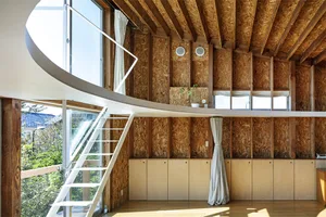 Modern design loft interior with wooden walls and ceiling, OSB panels, and large windows.