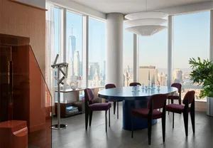Modern dining room featuring a round marble table and upholstered purple chairs