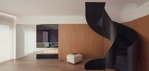 Modern residential interior featuring a spiral staircase with black metal spiral and wooden steps.