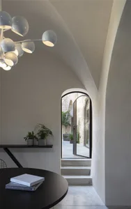 Angular concrete staircase leading to an industrial-style loft with modern furniture and exposed concrete walls.