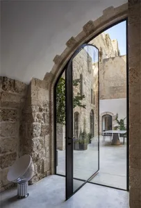 Modern entrance featuring glass doors and stone walls, showcasing contemporary architectural design.