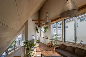 A modern industrial living room with wooden floors, glass windows, and metal pendant lights.