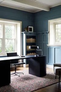A modern workspace with dark wood furniture and industrial design elements.