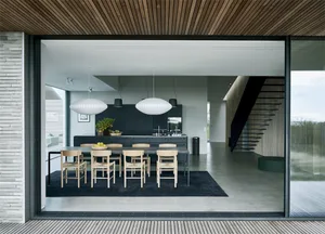 Modern minimalist kitchen with concrete finishes and a long dining table.