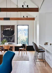A modern dining room featuring marble countertops, wooden flooring, and upholstered chairs.