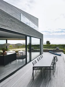 Modern residential architecture featuring wood and metal materials with a glass curtain wall.