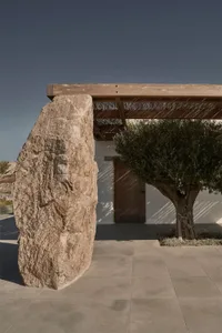 Modern residential entrance featuring natural stone and concrete materials.