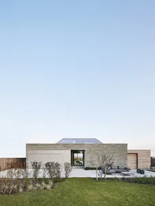 Modern minimalist house with stone and glass exterior features.