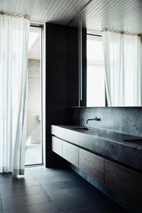 Minimalist modern bathroom featuring concrete materials, with large windows draped in sheer white curtains and a floating van