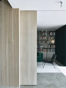 A modern library with wooden paneling and a collection of books on shelves.