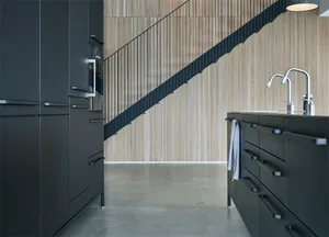 Modern, minimalist kitchen with black cabinets and a wooden backsplash.