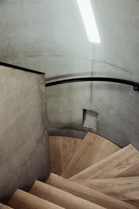 A modern staircase featuring a combination of concrete and wooden steps.