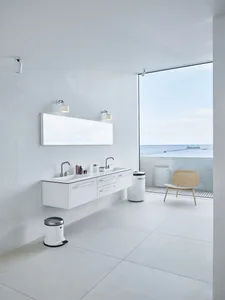Modern minimalist white bathroom with a view of the ocean.