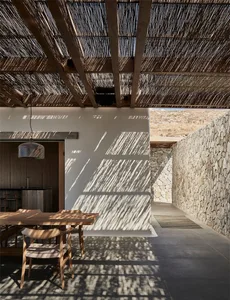 Modern residential patio featuring a woven ceiling and wooden dining table in a minimalist design