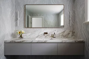 A modern bathroom featuring marble countertops and a sleek vanity.