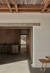 Modern minimalist kitchen with wooden finishes and a sleek black countertop.
