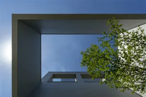 Modern building exterior with concrete material and clear blue sky.