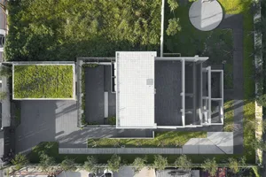 A modern building with a green rooftop and extensive greenery surrounding it.