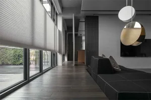 A modern minimalist living room featuring dark wood floors, wall paneling, and a glass divider.