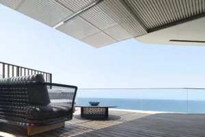 Modern deck overlooking the sea, featuring wood and metal materials.