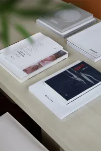 Stack of books and papers on a light-colored desk.