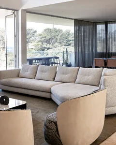 Modern minimalist living room featuring a comfortable sofa with plush cushions, and a stylish armchair with a unique pattern.