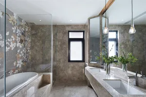 Modern bathroom with marble tiles, large window, and glass shower enclosure.
