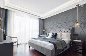 A modern bedroom featuring a grey upholstered bed with a geometric pattern on one wall.