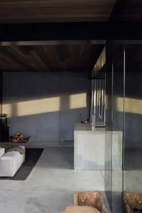 A modern industrial kitchen featuring a concrete kitchen island with a minimalist design, characterized by clean lines, expos