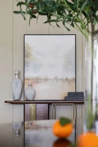 A modern living room featuring neutral-toned decor with minimalist furniture and abstract artwork.
