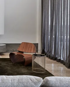 A modern living room featuring a wooden armchair and a metal side table.