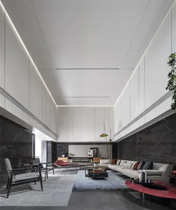A modern, minimalist living room featuring marble elements and a high, open ceiling.