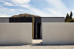 Modern minimalist house exterior with concrete facade and black window frames.