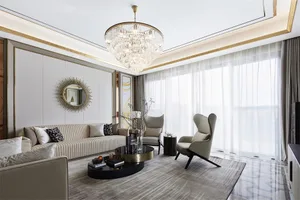Modern living room with white leather furniture and a large floor-to-ceiling window.