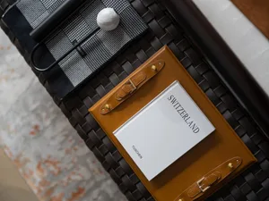Switzerland travel book with a leather case displayed on a woven surface.