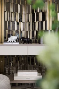 Two ceramic elephant sculptures, one white and one black, placed on top of a white surface with a white ceramic drawer unit.