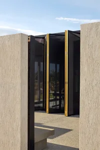 Modern, minimalist architecture featuring large glass doors and windows.