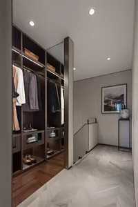 Modern closet featuring dark wooden shelves and cabinets with marble flooring and accents.