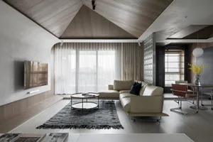 A modern, minimalist living room with concrete aggregate floors and walls, featuring a comfortable sofa, coffee table, and la