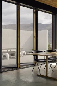Modern dining room extension featuring concrete and steel with glass elements.
