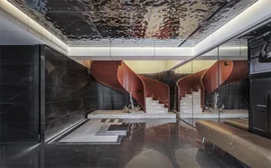 Modern residential entrance featuring red metallic stack-cladding and black marble surfaces