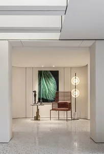 A modern, metallic entryway featuring minimalist design elements and a vibrant, abstract painting.