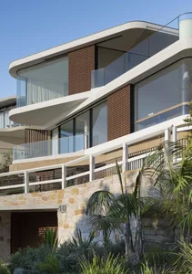 Modern residential house featuring glass, wood, stone, and metal exterior materials.